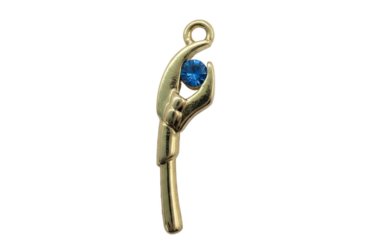 Polished gold hand holding a round faceted blue gem on a black background