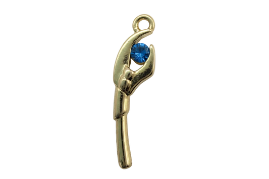 Polished gold hand holding a round faceted blue gem on a black background