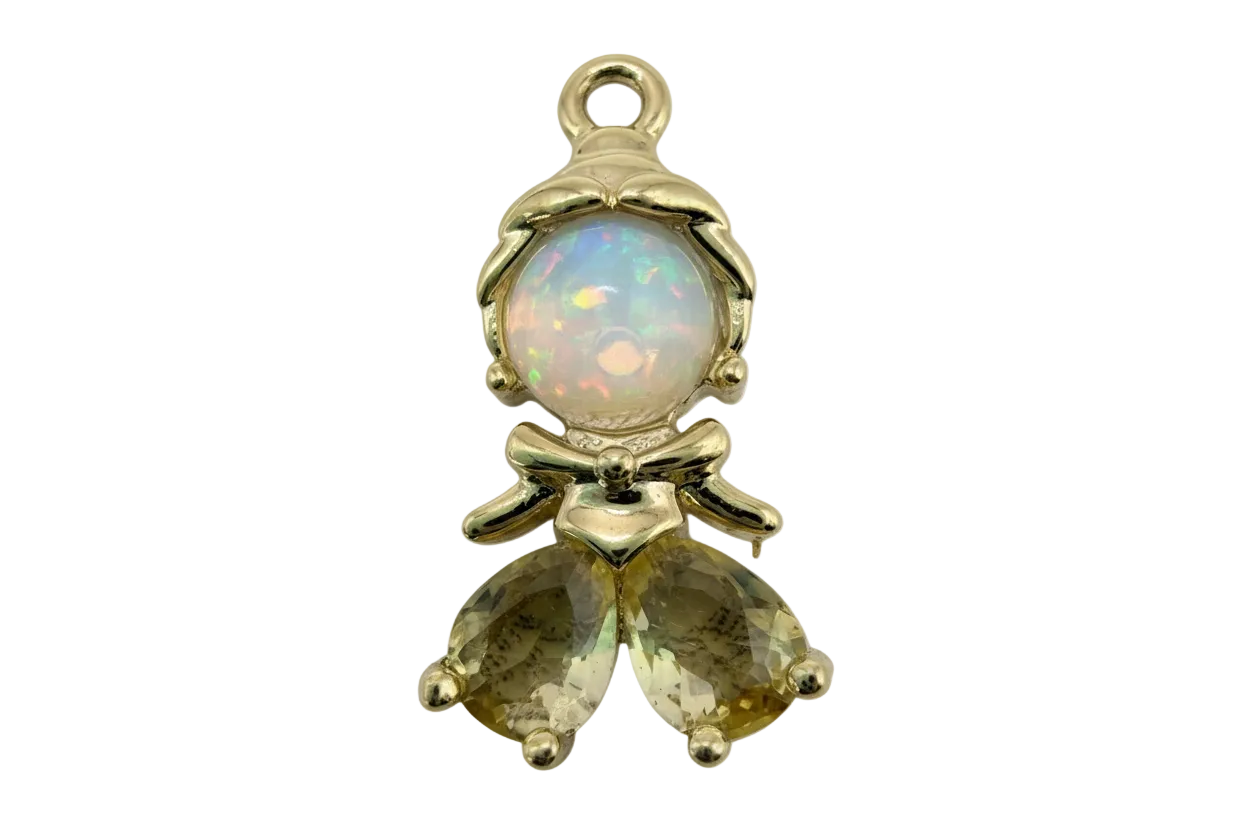 Polished gold figure with clear domed crystal and two faceted pale yellow teardrop gems, bow detail