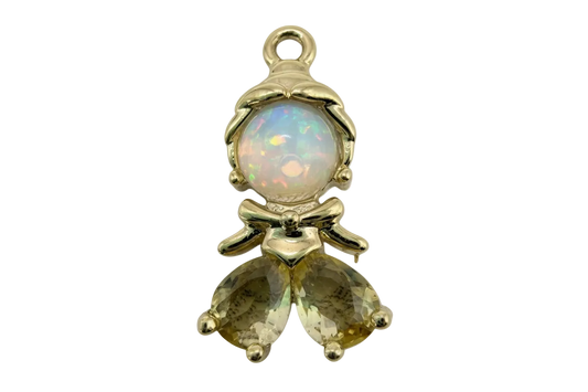 Polished gold figure with clear domed crystal and two faceted pale yellow teardrop gems, bow detail