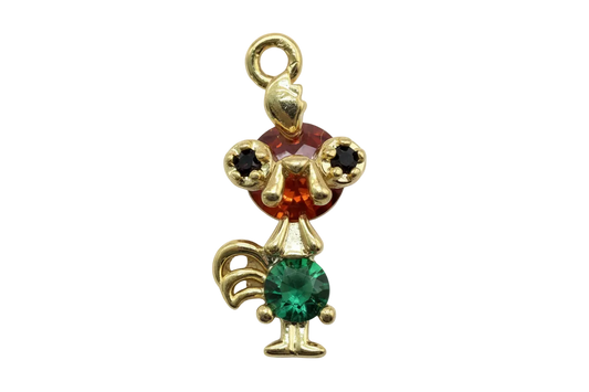Gold mouse figure with faceted red head gem, green body gem, and black ear stones