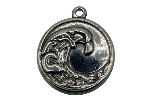 Silver round medallion with raised ocean wave relief and antiqued shadow detailing