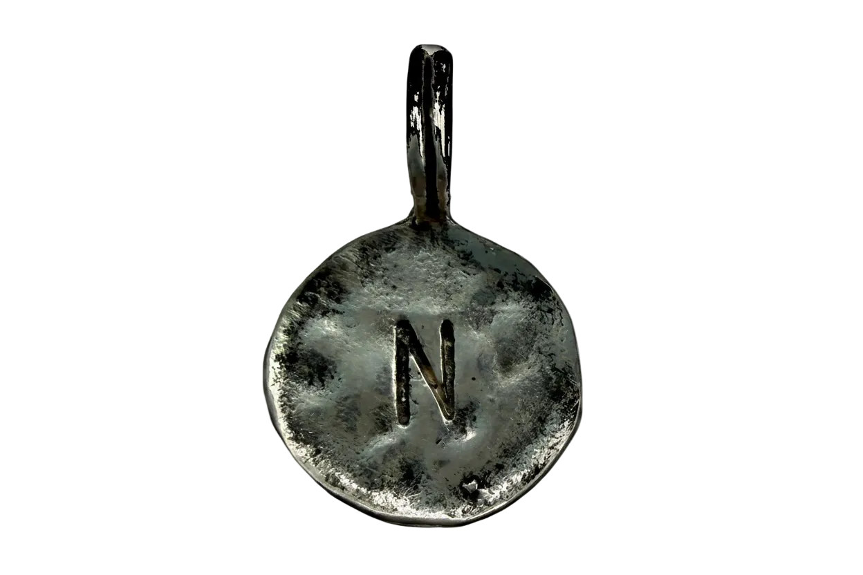 Round hammered silver coin charm with stamped letter N and oxidized texture