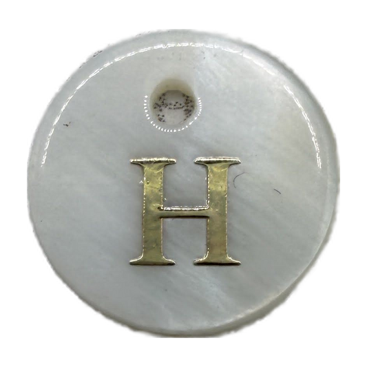 Glossy white round disc with gold letter H
