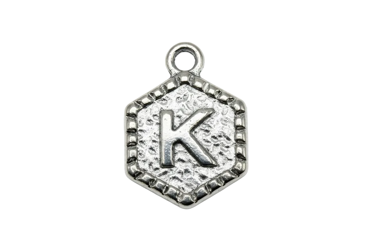 Antiqued silver textured medallion with raised letter K and sculpted border