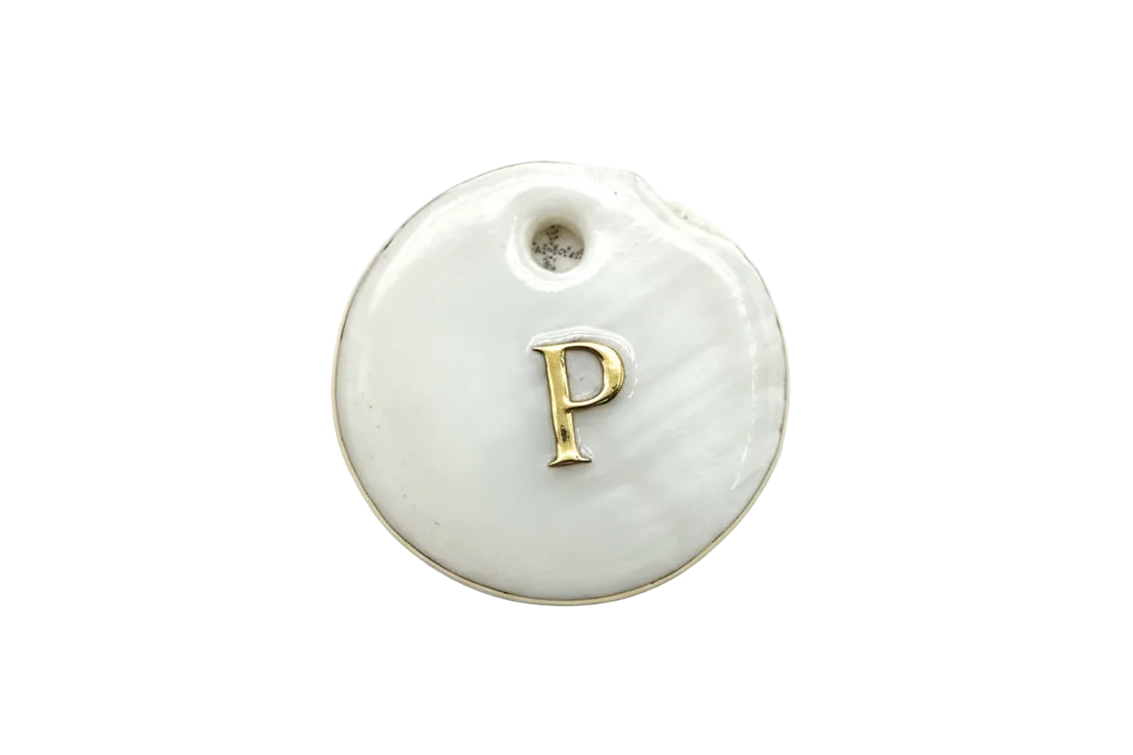 Round white disc with raised gold letter P on a glossy surface
