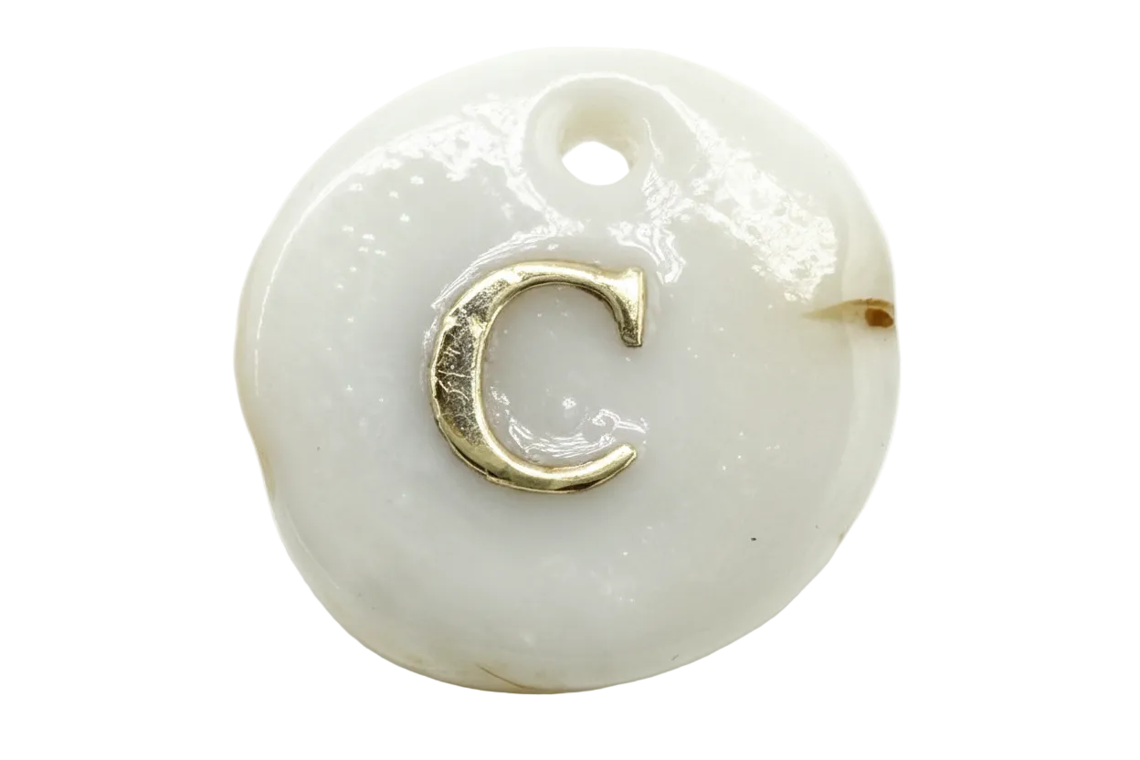 Glossy white round disc with raised gold letter C
