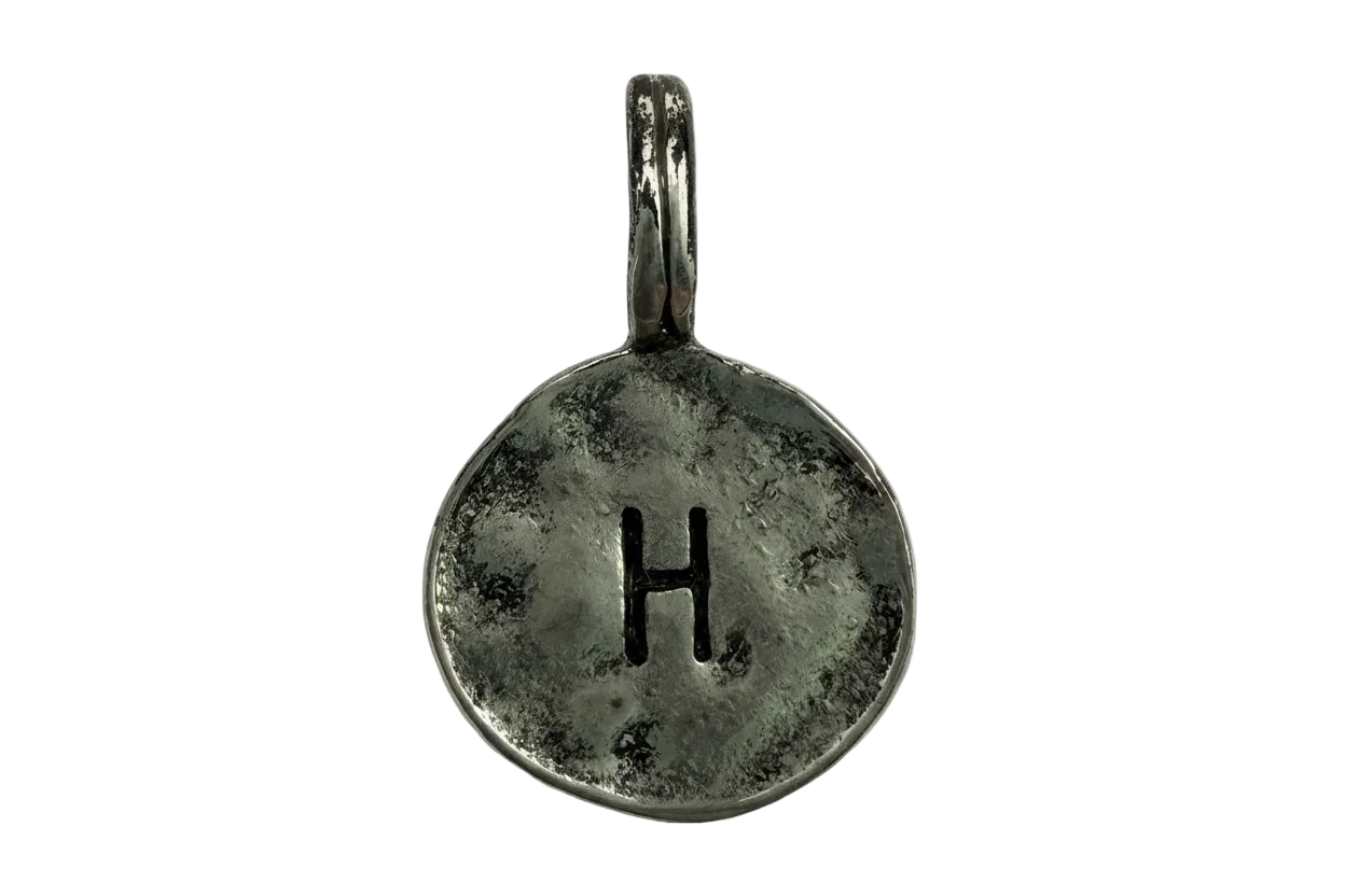 Antiqued silver round coin charm with stamped letter H and darkened patina