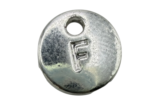Polished silver-tone round disc with raised letter F