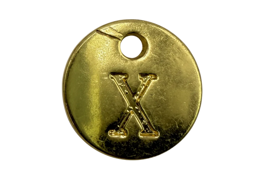 Gold round coin with raised letter X and small clear gem accent