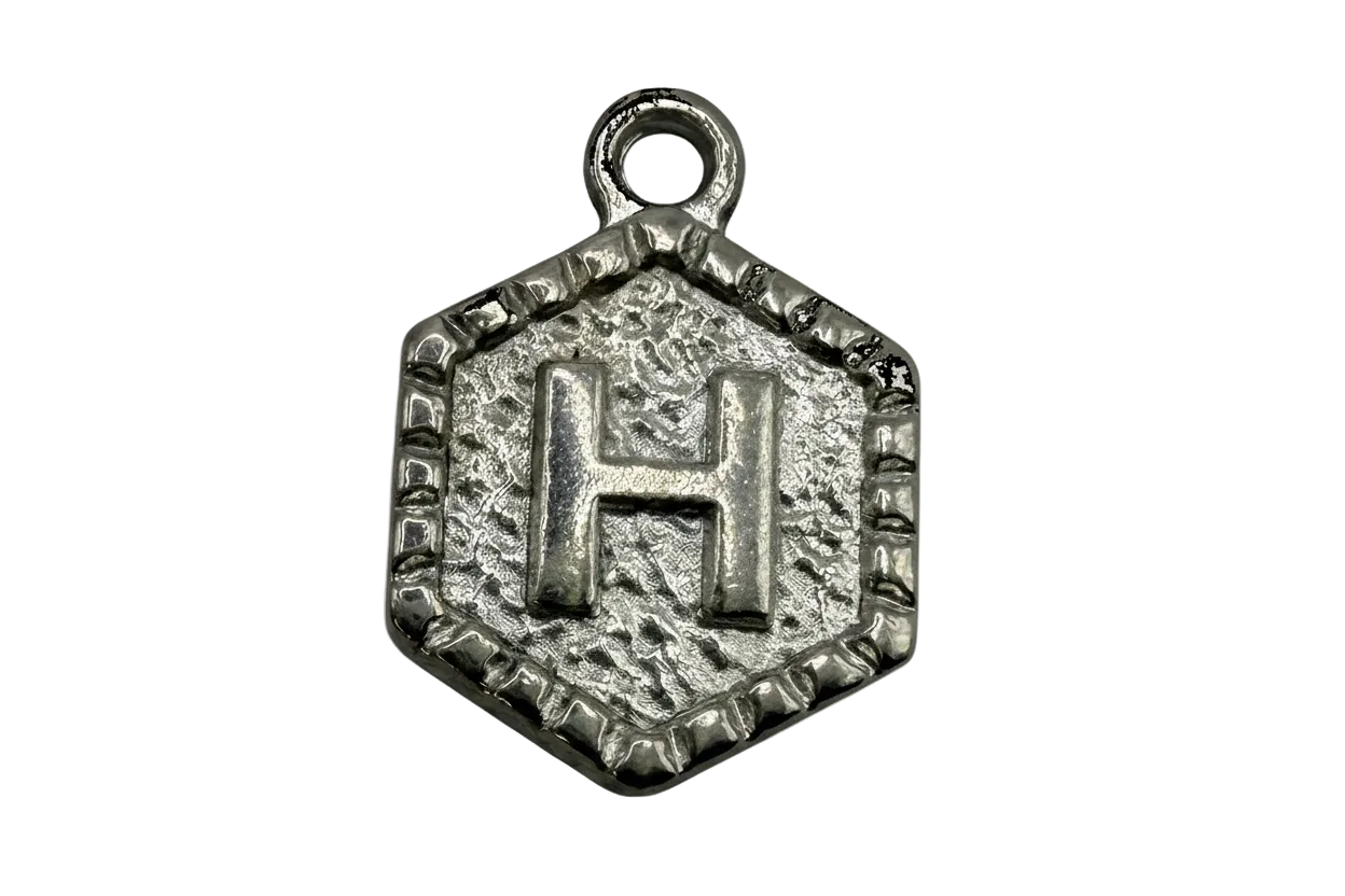 Textured silver-tone hexagon medallion with raised letter H and antiqued detailing