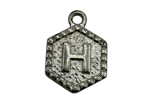 Textured silver-tone hexagon medallion with raised letter H and antiqued detailing