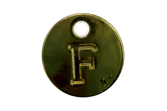 Polished gold round disc with raised letter F