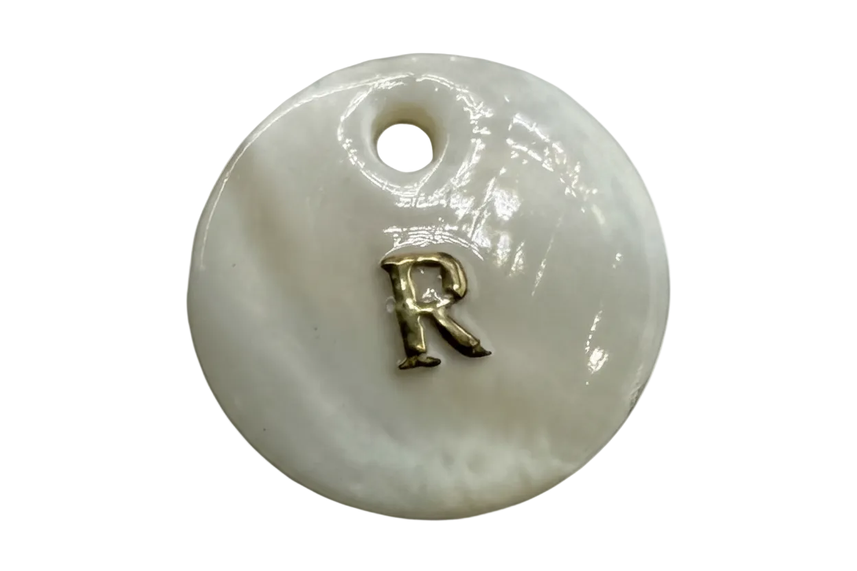 Glossy white round disc with raised gold letter R
