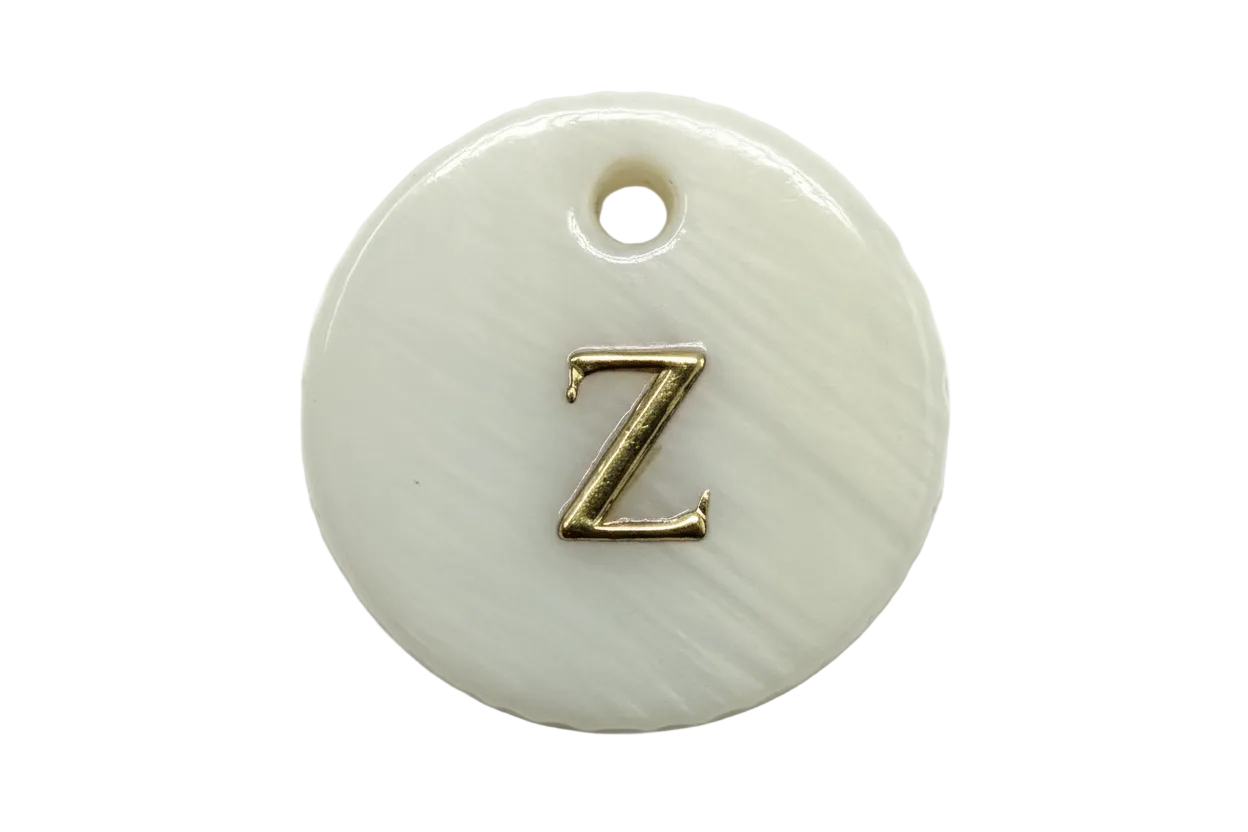 Glossy white round disc with raised gold letter Z