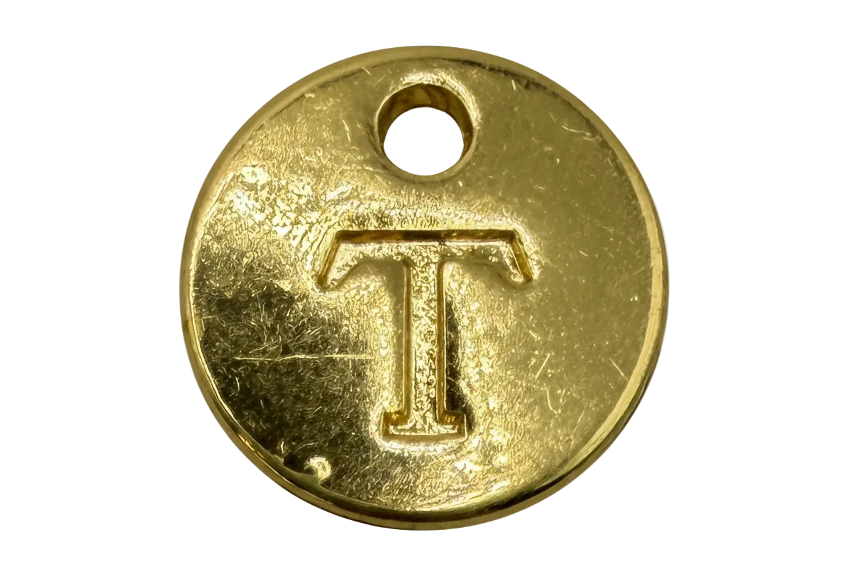 Round gold coin with engraved letter T and small top hole