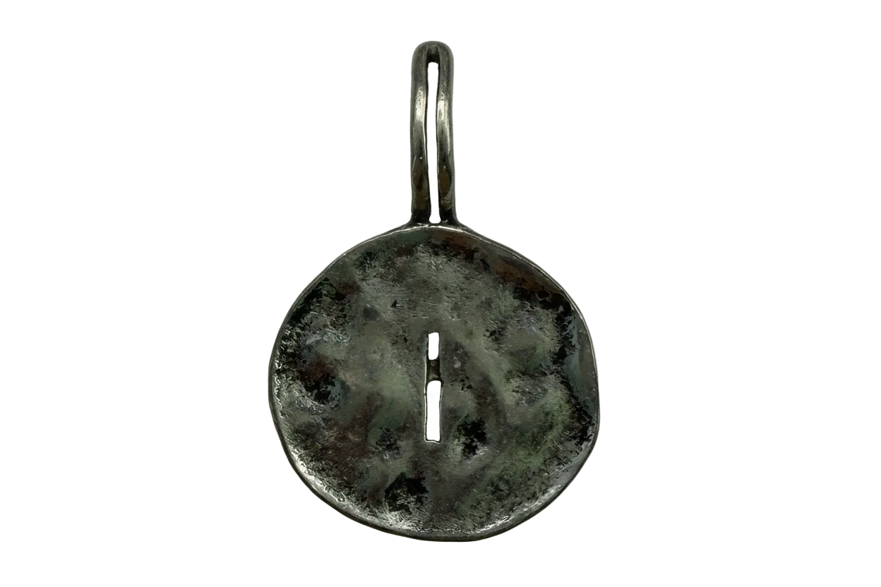 Antiqued silver round token with a central slit and mottled patina finish