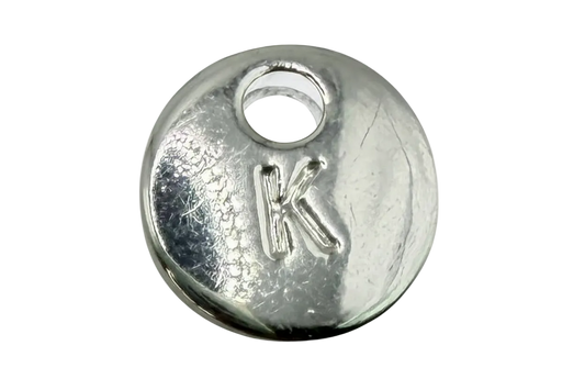 Round silver initial coin with raised letter K