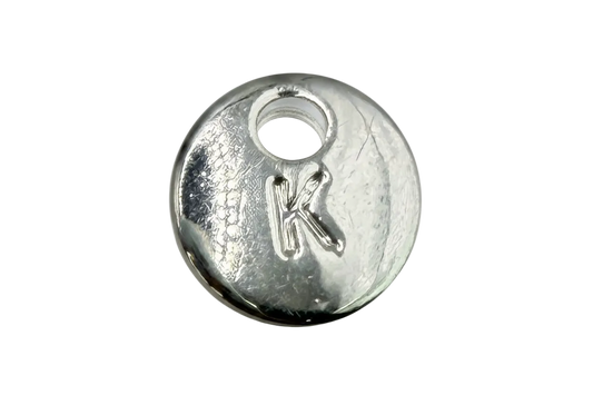 Polished silver round disc with raised letter K initial and subtle texture