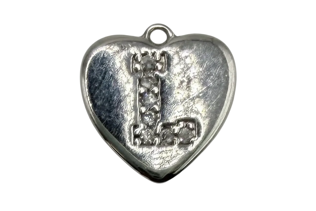 Silver heart with raised letter L accented by clear pavé stones on a textured background