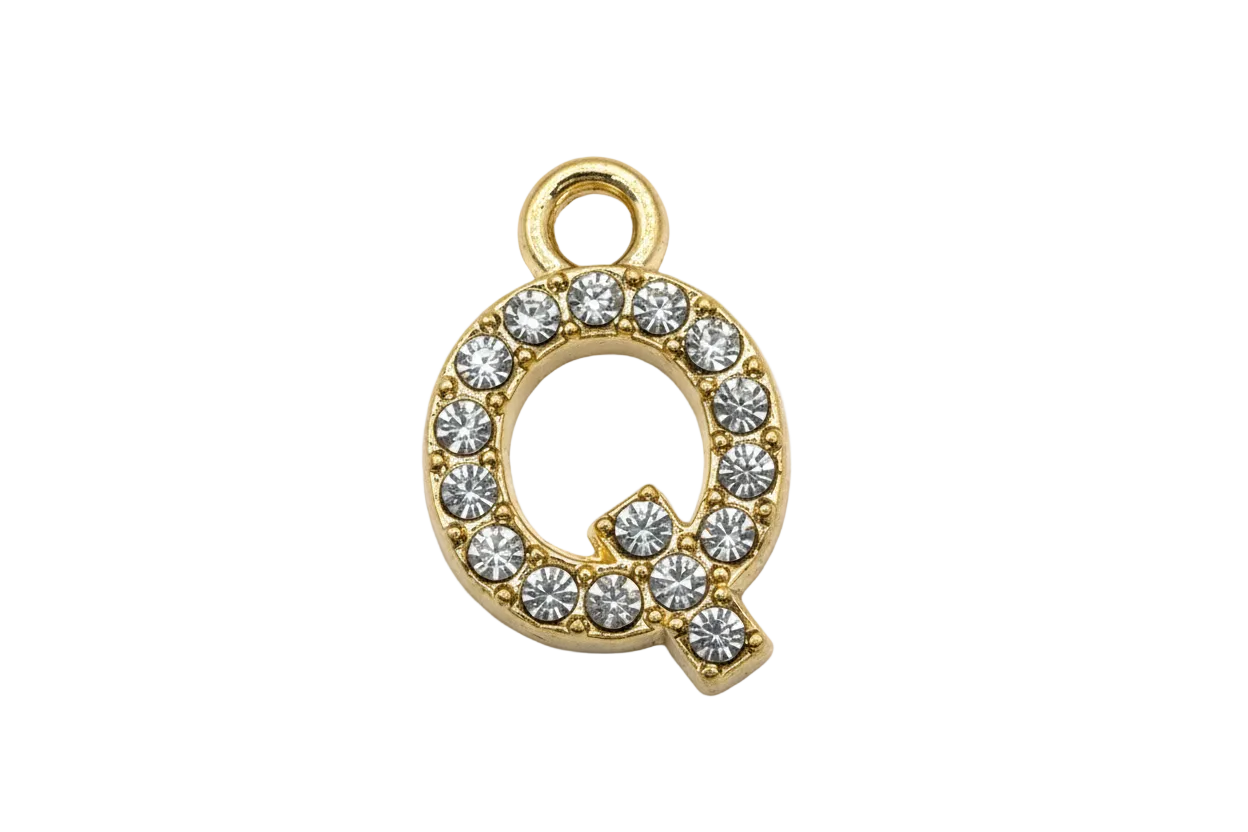 Gold letter Q initial with pavé clear crystals on a black background