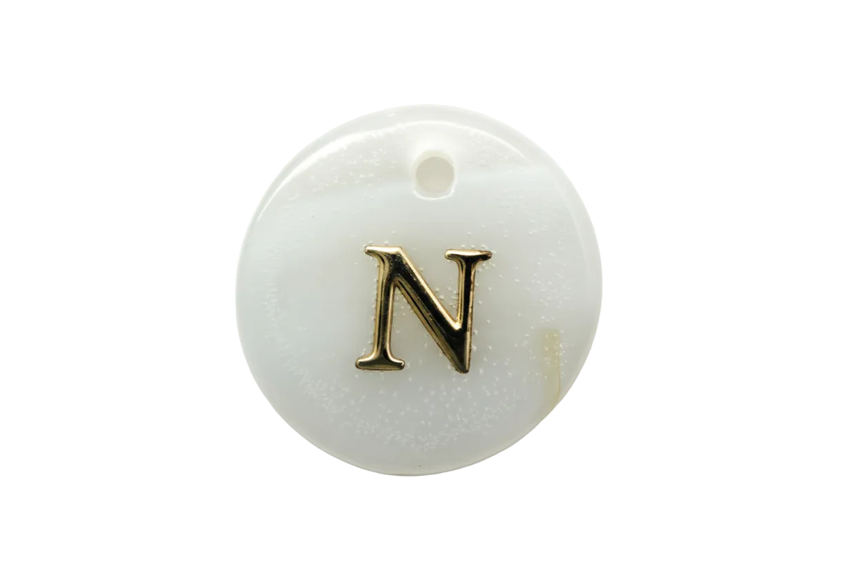 Glossy white round disc with raised gold serif letter N and black accent