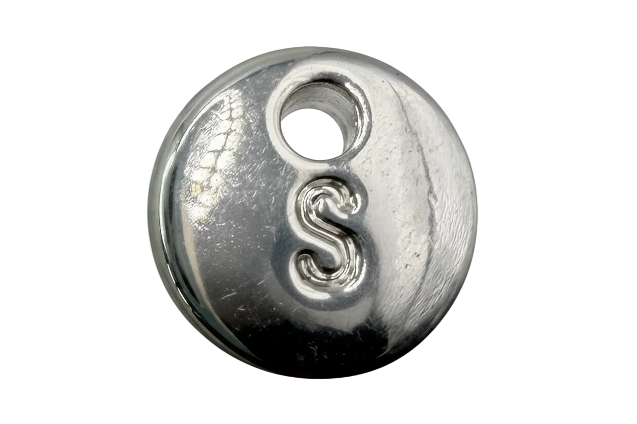 Polished silver round disc with raised letter S and small grey cabochon accent