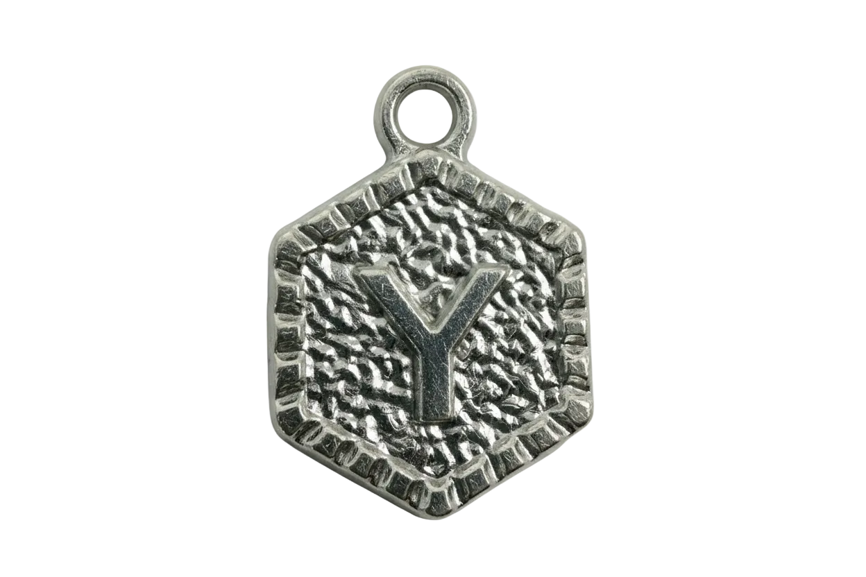 Silver hexagon medallion with raised letter Y and textured, oxidized finish