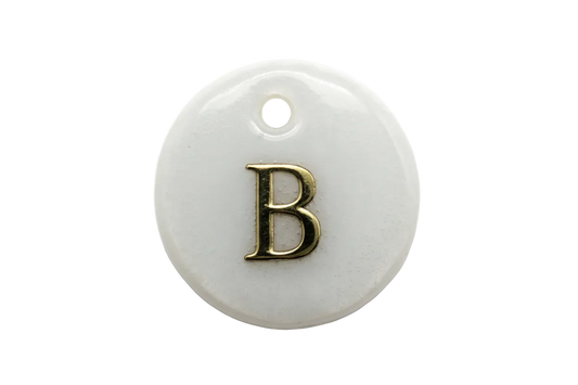 Iridescent pearl-white round disc with raised gold letter B
