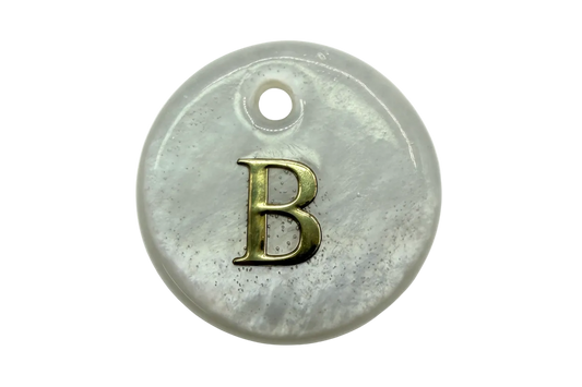 Glossy pearlescent white round disc with raised gold letter B