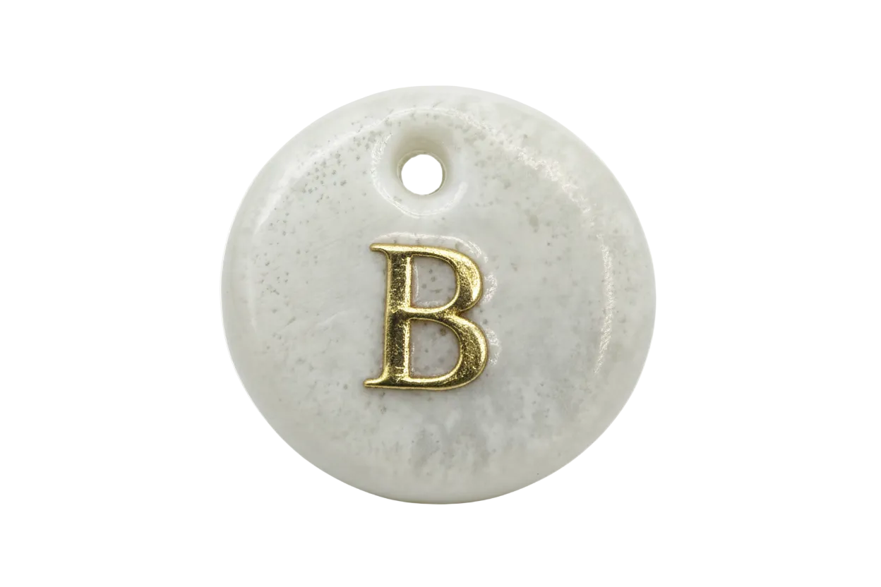 Glossy marbled white round disc with raised gold letter B
