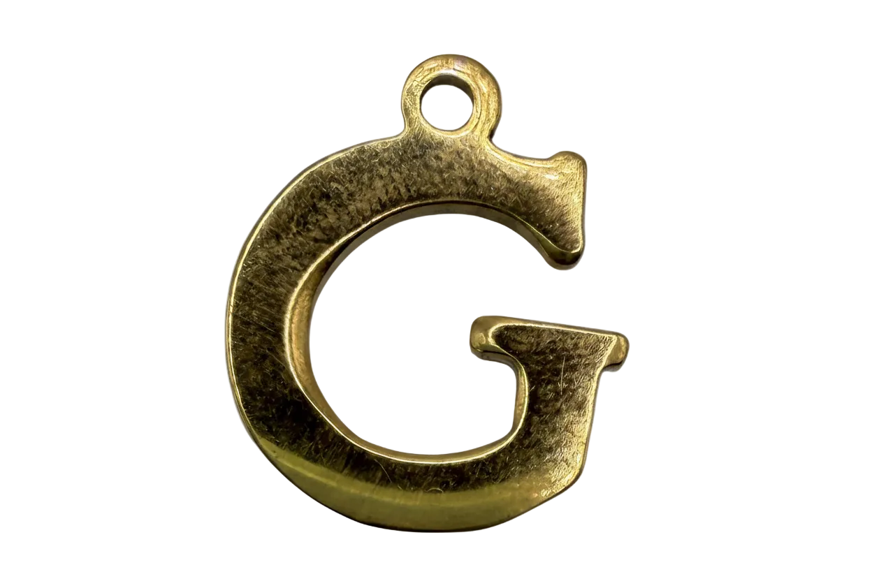 Gold letter G initial pendant with textured finish on black background
