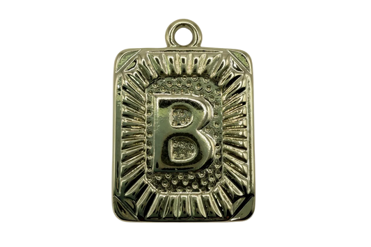 Gold rectangular initial B tablet with raised letter and textured sunburst border