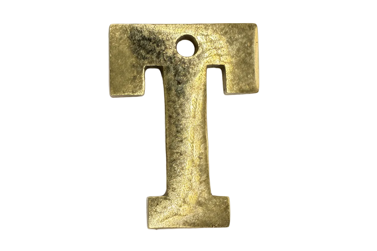 Textured gold serif letter T initial with a softly distressed finish