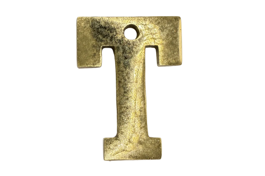 Textured gold serif letter T initial with a softly distressed finish