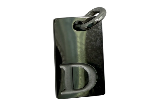 Oxidized silver rectangular tag with raised letter D and polished top ring detail