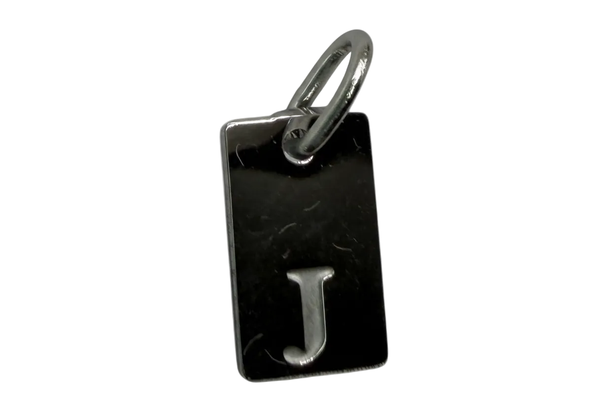 Rectangular black tag with raised silver letter J and polished finish