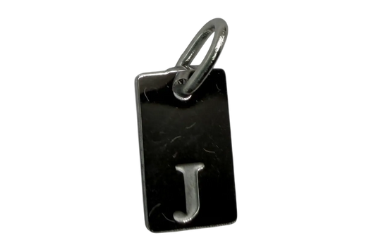Rectangular black tag with raised silver letter J and polished finish