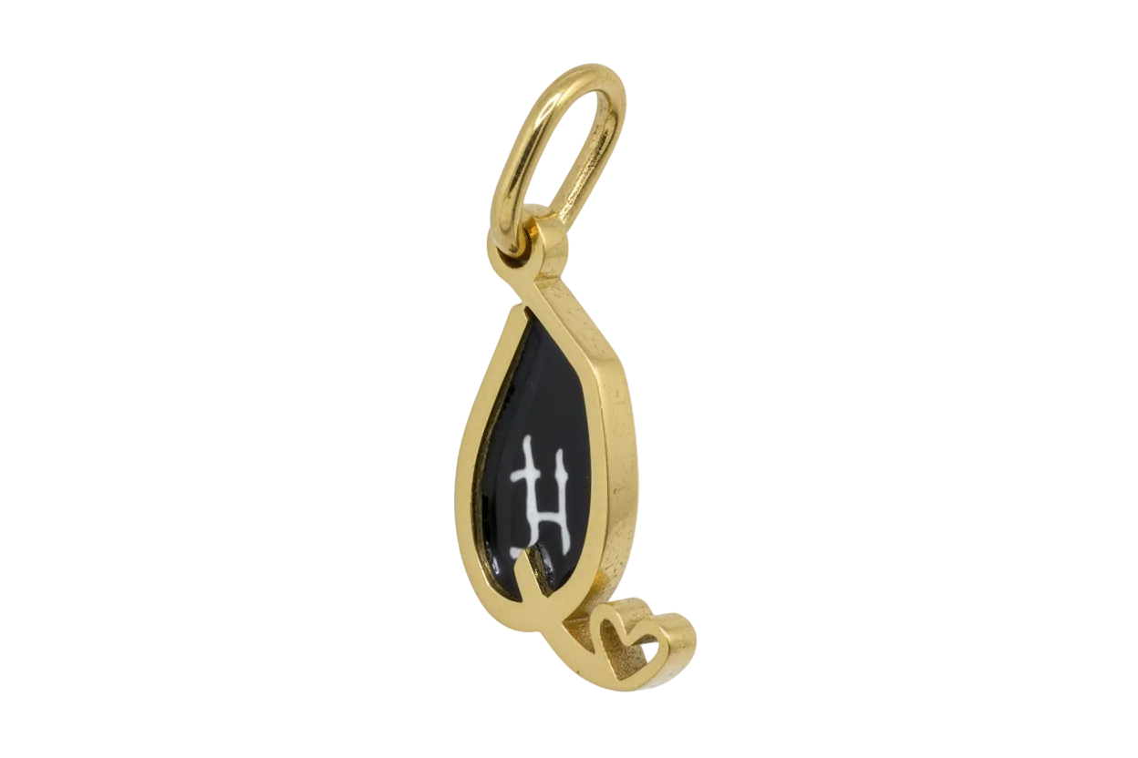 Gold teardrop pendant with black enamel center, white letter H, and small heart detail