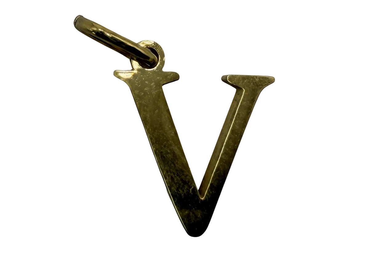 Polished gold letter V initial charm on black background