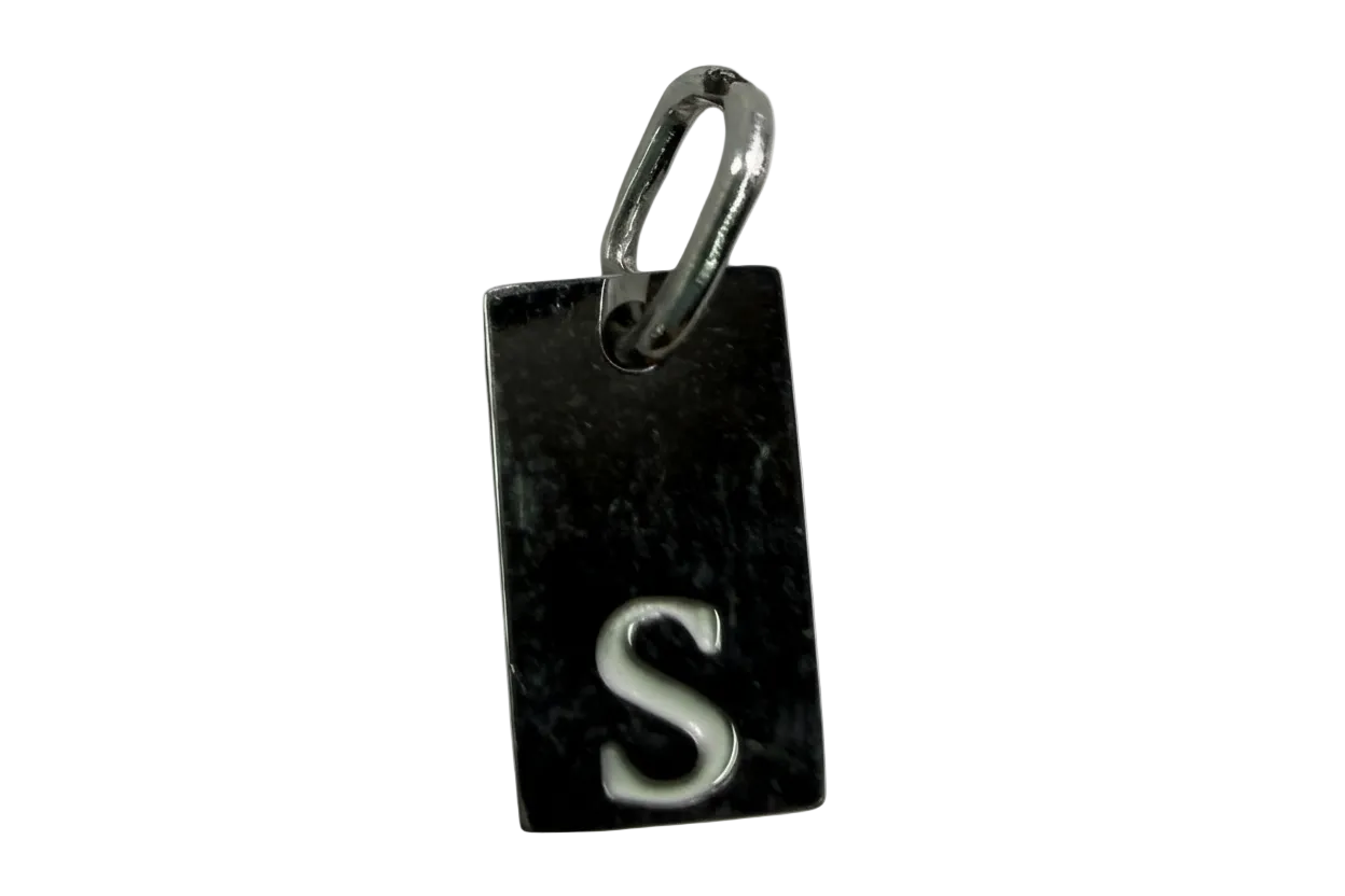 Rectangular black tag with raised silver letter S and polished silver-toned edge