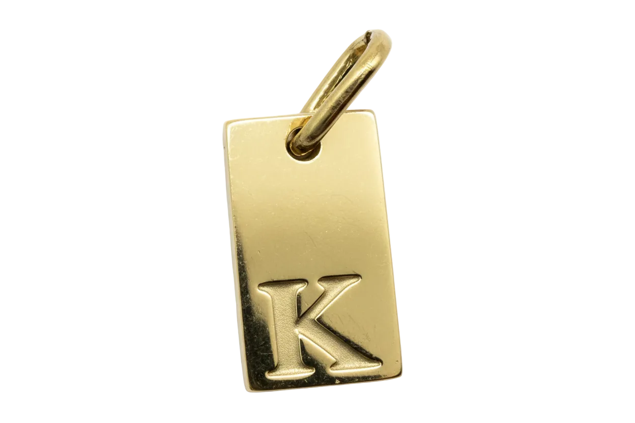 Polished gold rectangular tag with raised letter K initial