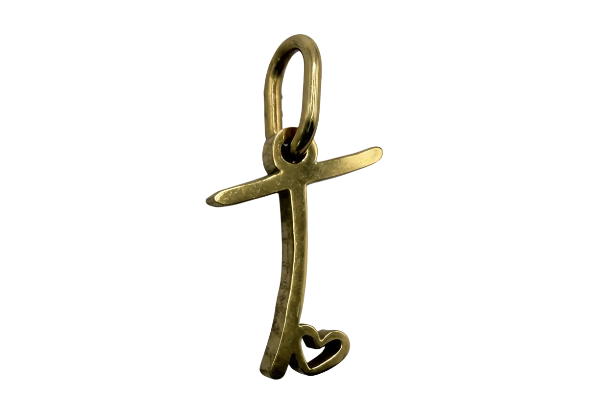 Gold script letter T with an open heart detail on a black background