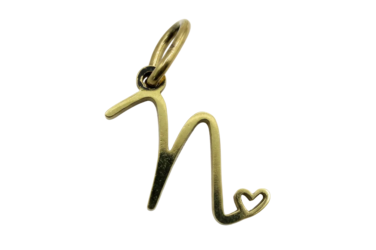 Polished gold script letter M with a small open heart detail