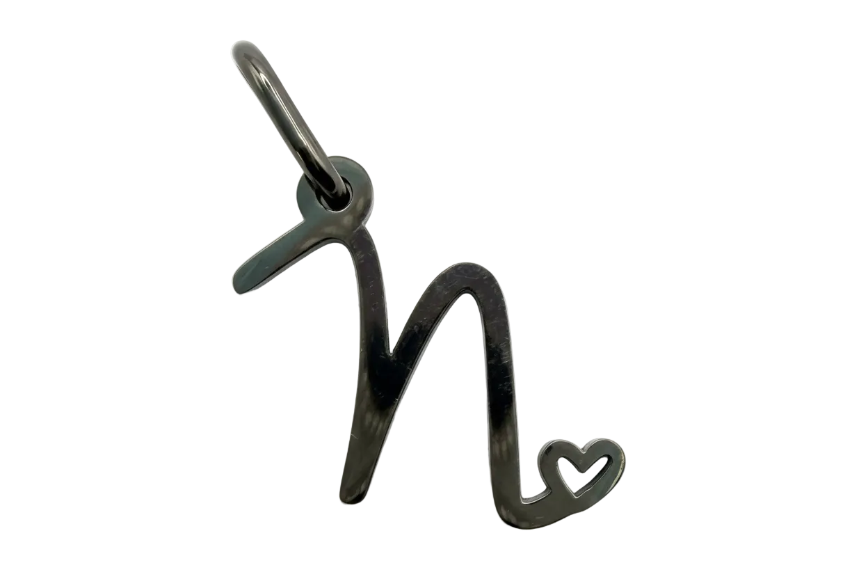Polished silver script letter N with small open heart accent