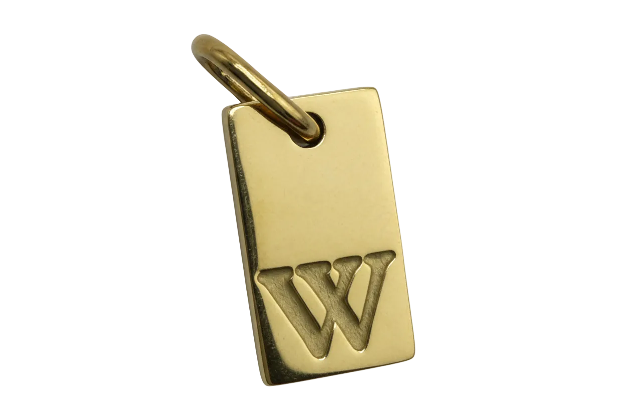Gold rectangular tag charm with raised letter W
