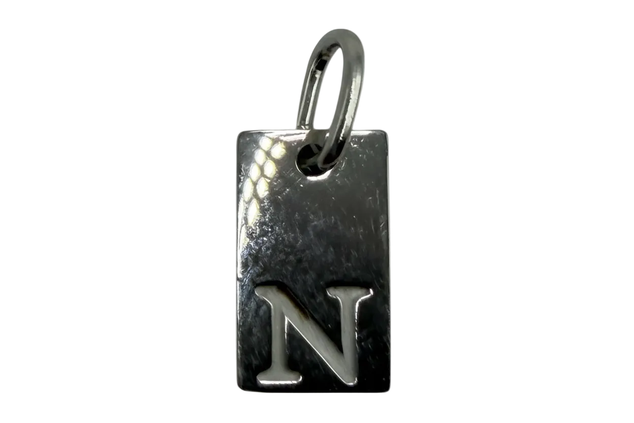 Polished silver rectangular tag with raised letter N initial