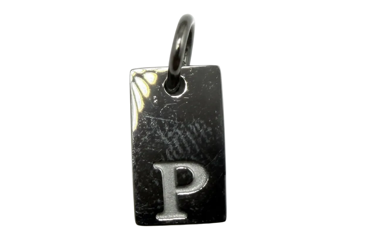Glossy dark rectangular tag with raised silver letter P