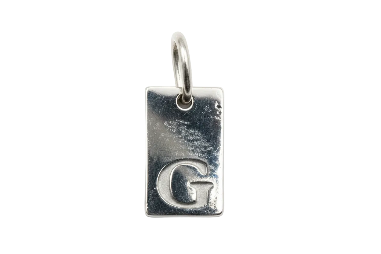 Polished silver rectangular tag with embossed letter G