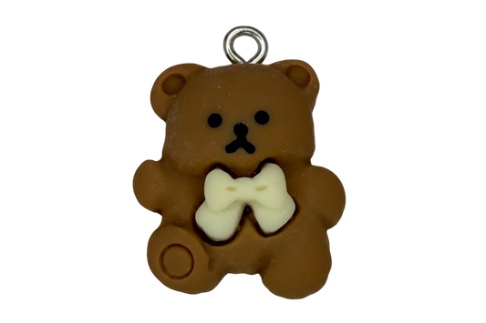 Brown teddy bear charm with ivory bow and black face details, silver top